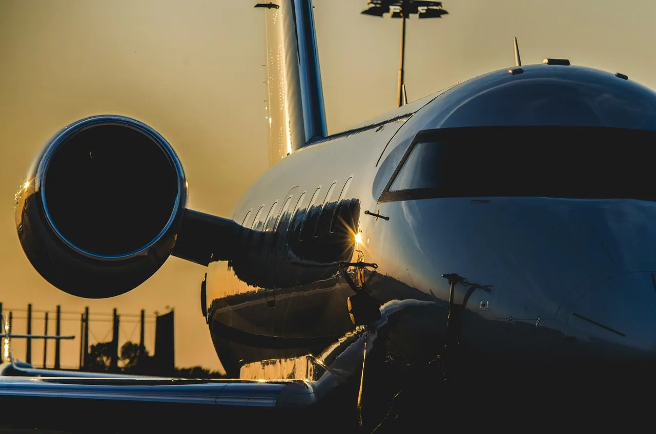 Close-up of a powerful private jet engine and fuselage reflecting the sunset